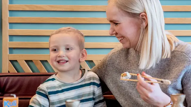 mor og sønn spiser på restaurant med godt humør
