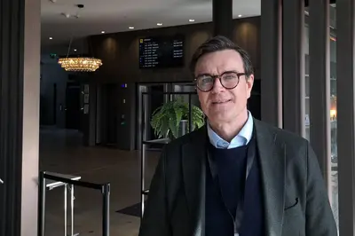 Portrettbilde av direktør for kjøpesenteravdelingen i Thon Gruppen, Thomas Rønning, som står i hotellresepsjon.