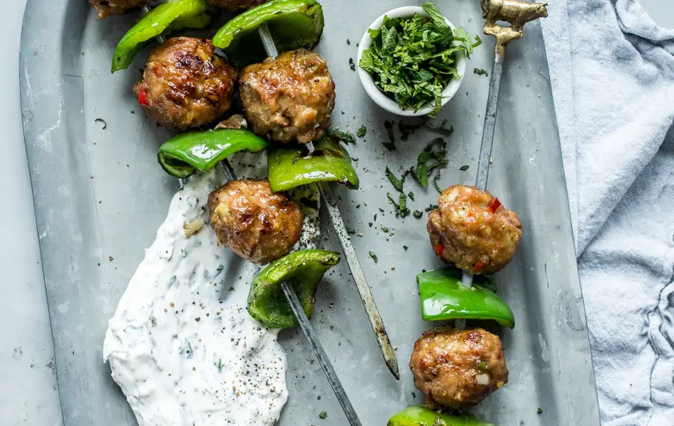 Grillspyd med kjøttboller og grønn paprika på et sølvfat