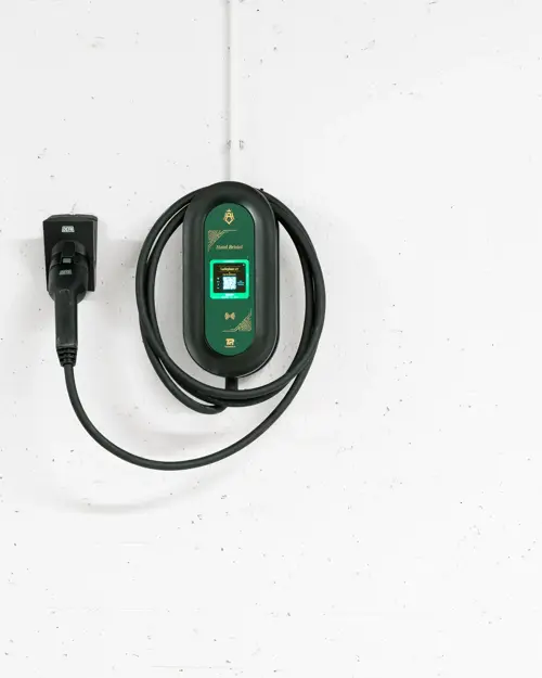 Ladekabel til el-bil henger på hvit vegg.