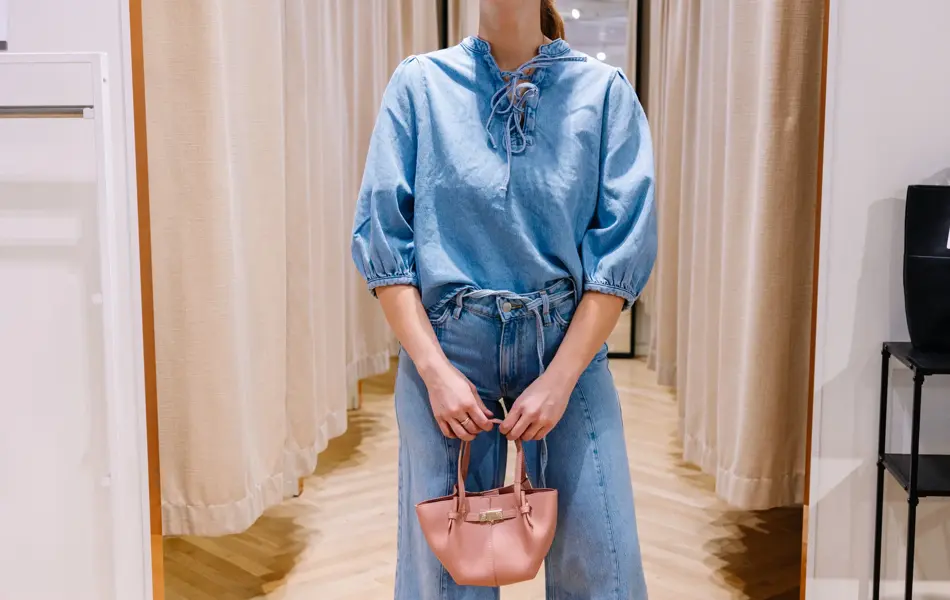 dame i vårklær står ved prøverom