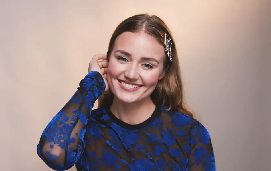 Smilende jente med festsminke fester håret bak øret