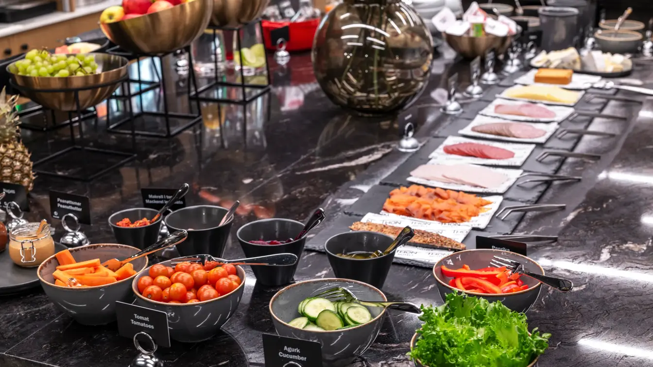 Frokostbuffet med diverse fargerik mat, oppskåret frukt, grønnsaker og pålegg.
