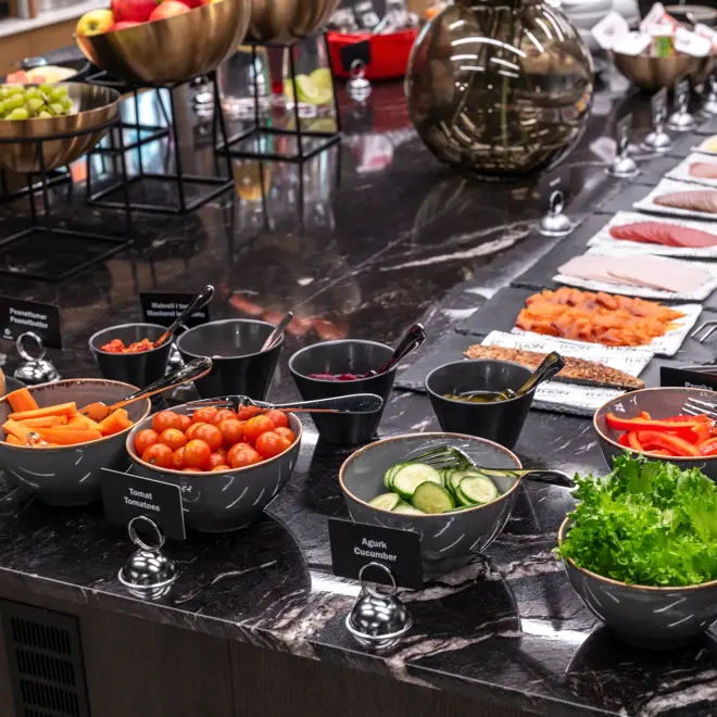 Frokostbuffet med diverse fargerik mat, oppskåret frukt, grønnsaker og pålegg.