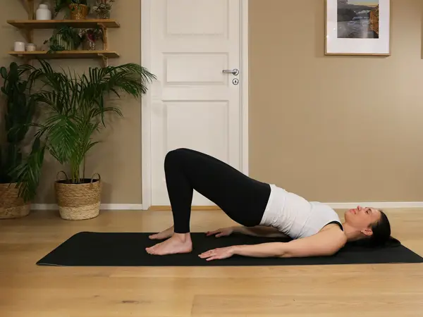 Anna viser Pilates-øvelser på treningsmatte på gulvet