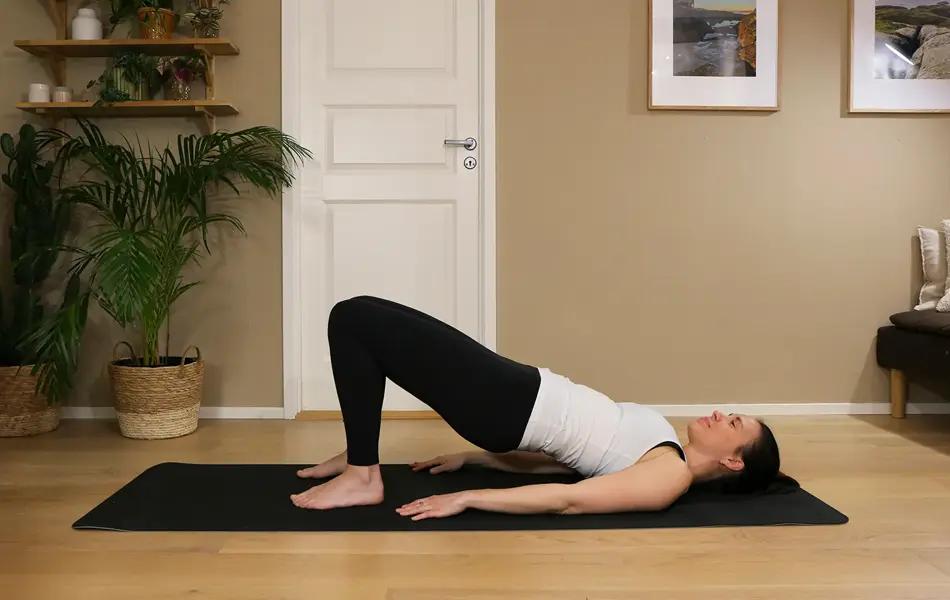 Anna viser Pilates-øvelser på treningsmatte på gulvet