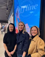Kathrine Ingerø, Kjersti Stople og Kristin Henriksen står foran en skjerm med reklamen på Sandvika Storsenter