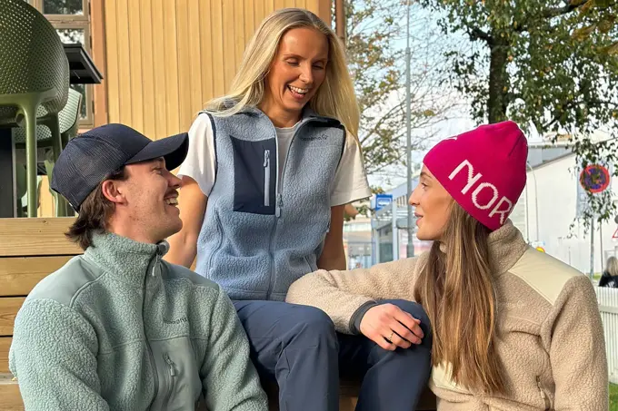 Tre personer som sitter og snakker og ler