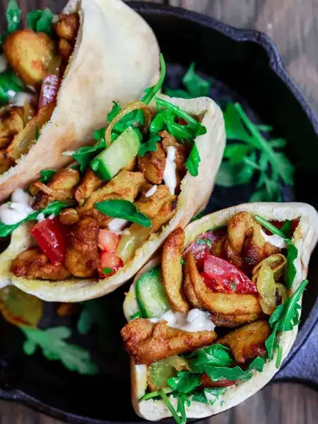 Tre kyllingkebab i pitabrød, stående i jernpanne