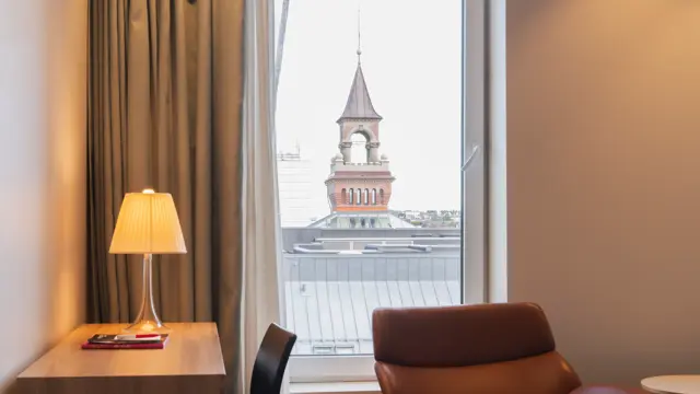 Nærbilde av skrivebord og lenestol foran vindu med utsikt på junior suite.