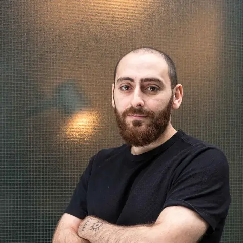 Yunus Yildiz poserer foran en mørk bakgrunn