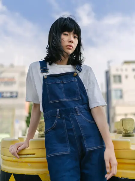 Kvinne i jeans poserer utendørs med vind i håret