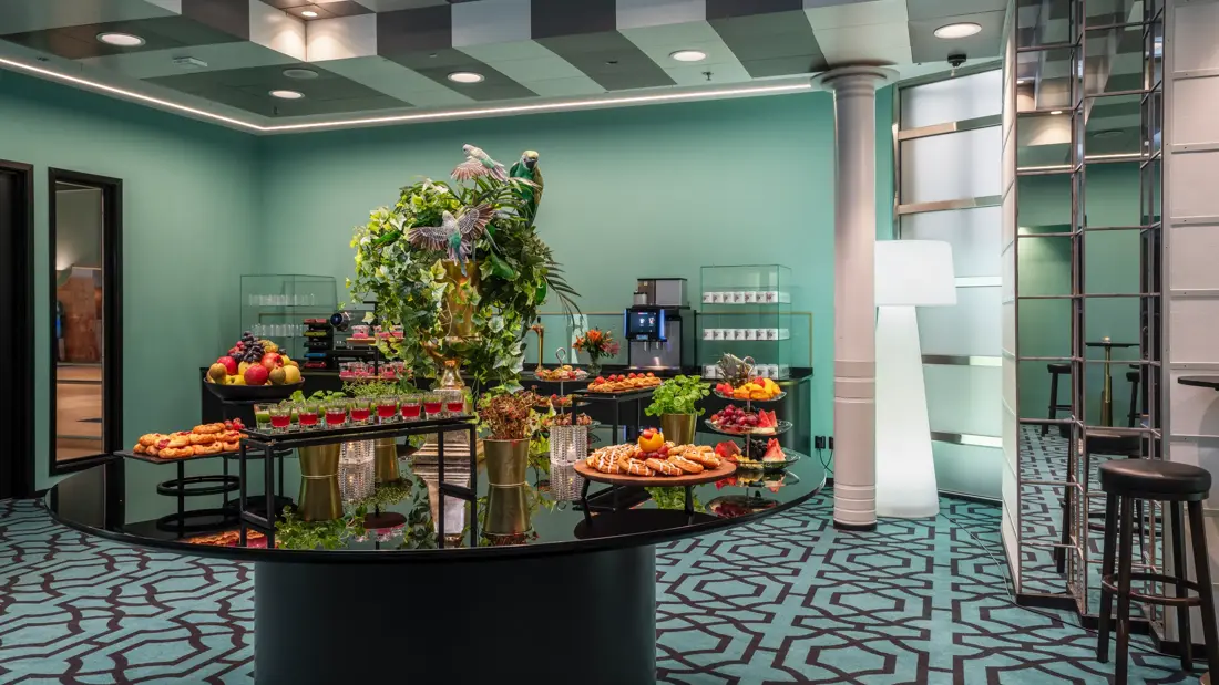 Pausebuffet med diverse fargerik mat på etasjefat, og grønne planter.