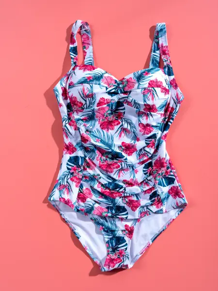 Hvit, burgunder og grå badedrakt på rosa bakgrunn