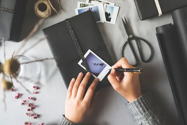 Skriver på et polaroidbilde oppå en bok