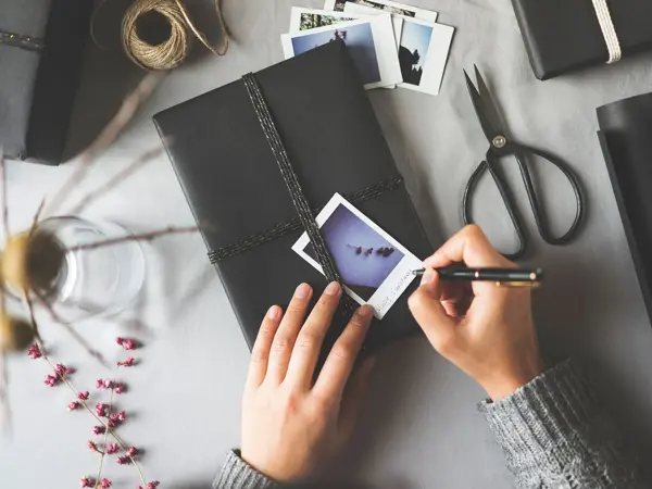 Skriver på et polaroidbilde oppå en bok