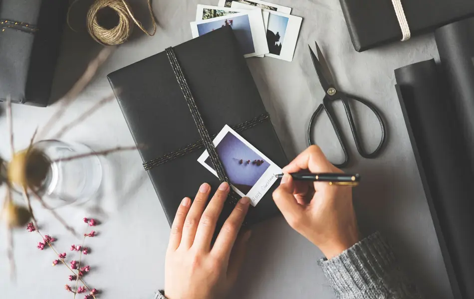 Skriver på et polaroidbilde oppå en bok