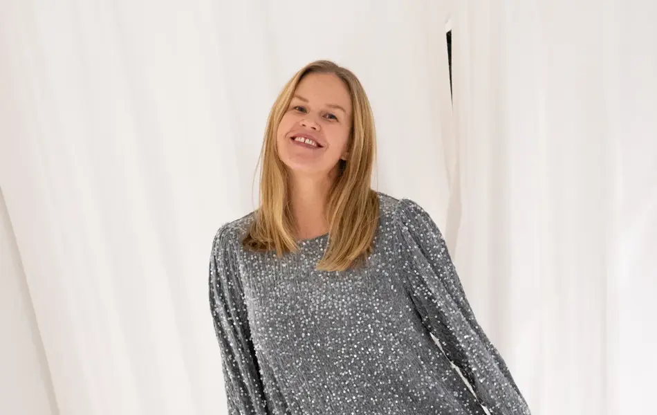 Dame med glitrende sølvkjole og sorte pumps.