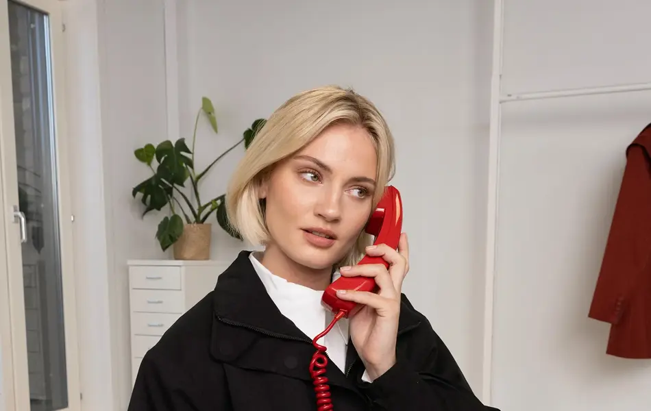 Dame som snakker i en rød telefon