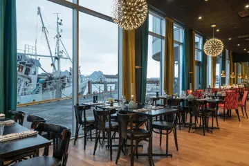 Frokostsal med utsikt mot båtlivet på Thon Hotel Lofoten i restaurant paelo artic 