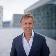 Portrett av Eirik Kildal. Han har på blå dress og smiler. 