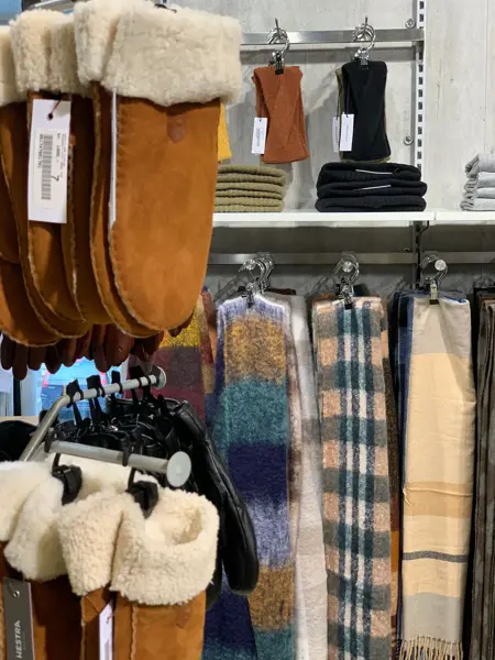 brune hansker og skjerf som henger på stativ