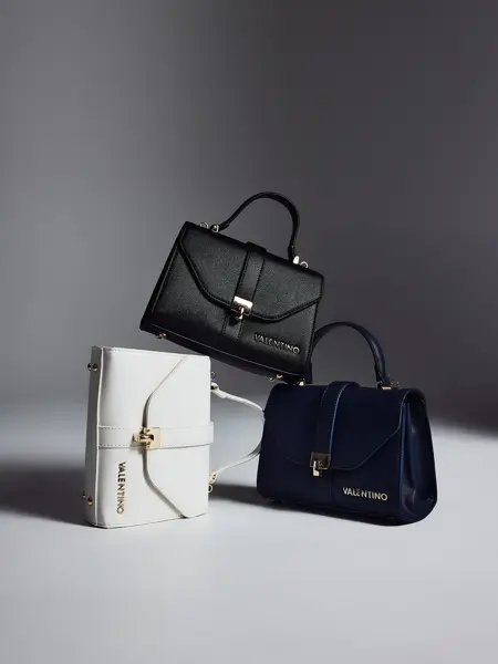 Tre skuldervesker i hvit, sort og mørekblå.