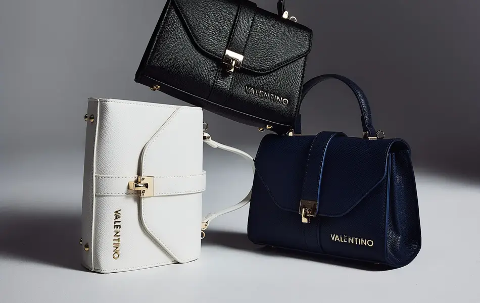 Tre skuldervesker i hvit, sort og mørekblå.