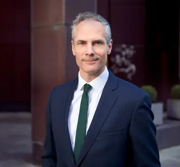 Colin Waddell, daglig leder i CBRE, poserer med dress i et mørkt rom 