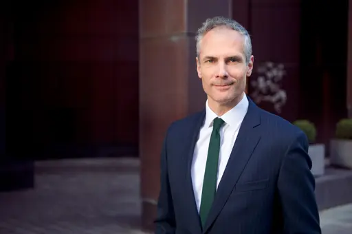 Colin Waddell, daglig leder i CBRE, poserer med dress i et mørkt rom 