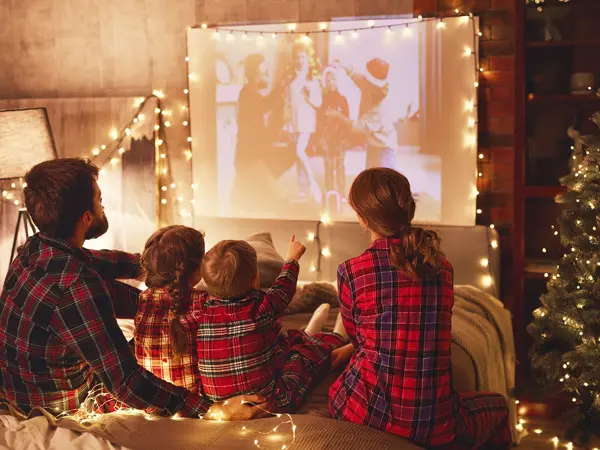 to barn, en far og mor som ser på hjemmekino