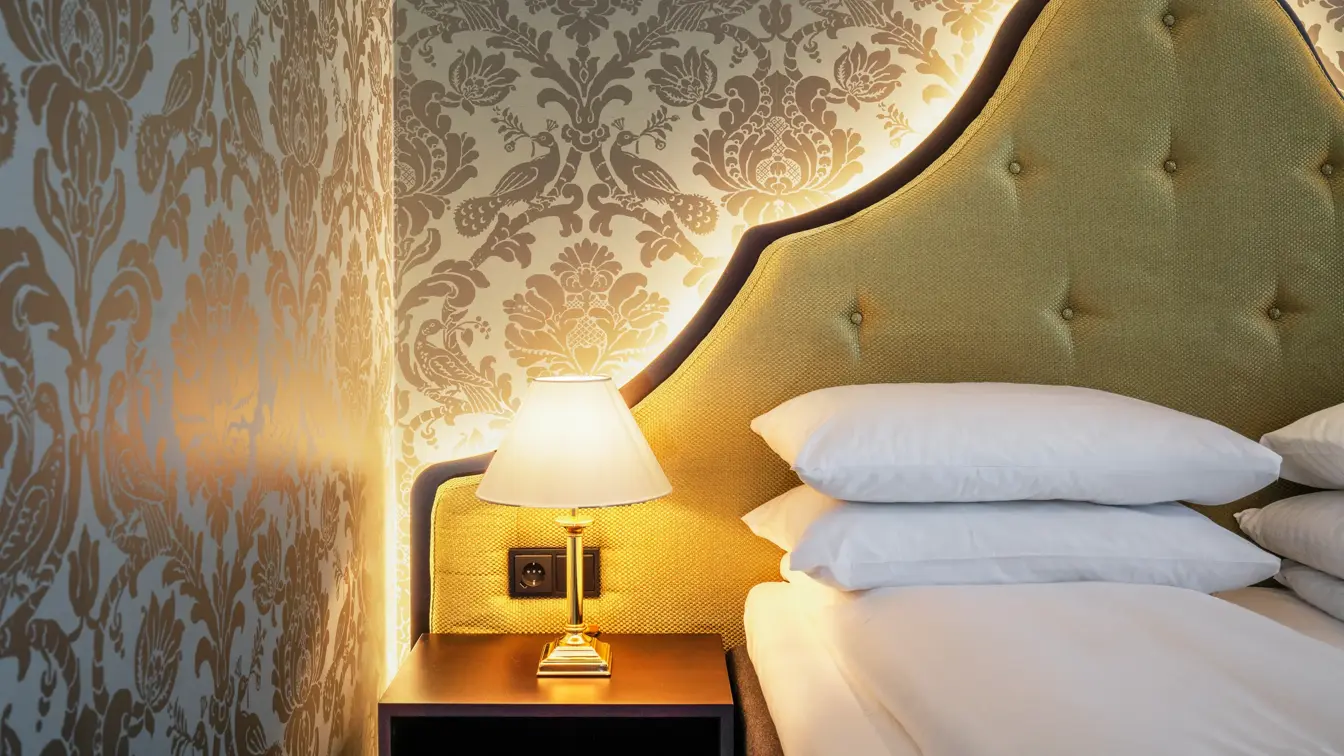 Mønstrete tapet og senggavel på rom på Hotel Bristol