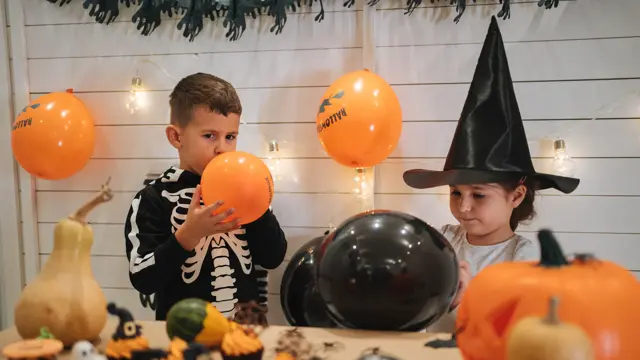 Cute siblings, a brother and a sister, enjoying their time together preparing and celebrating Halloween.