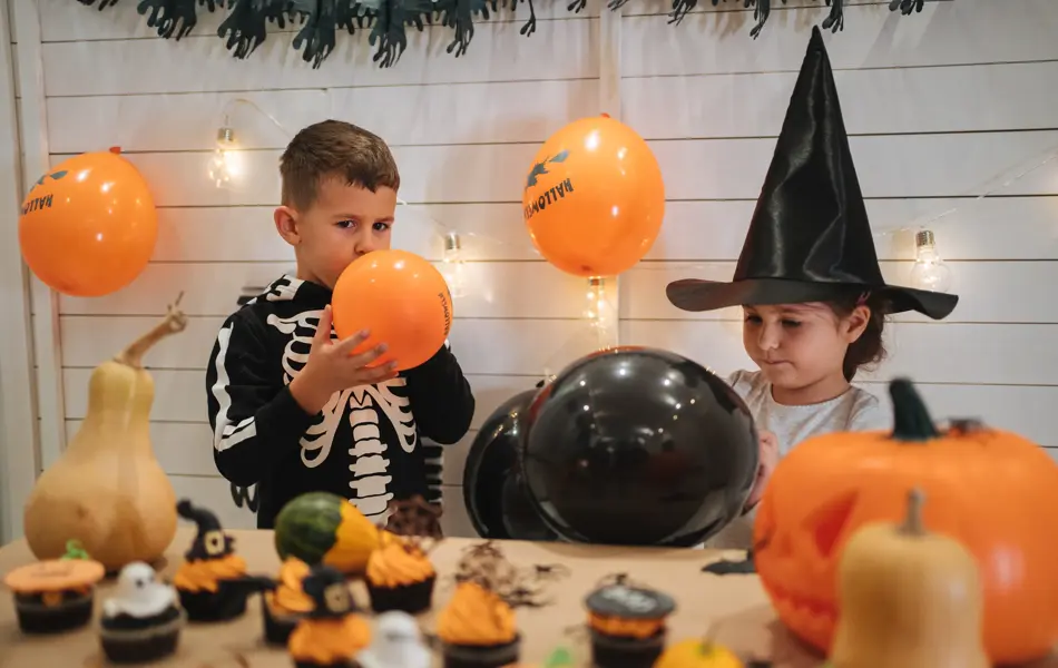 Cute siblings, a brother and a sister, enjoying their time together preparing and celebrating Halloween.