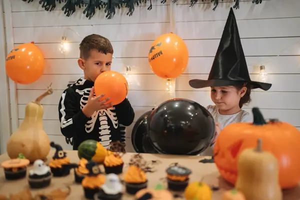 Cute siblings, a brother and a sister, enjoying their time together preparing and celebrating Halloween.