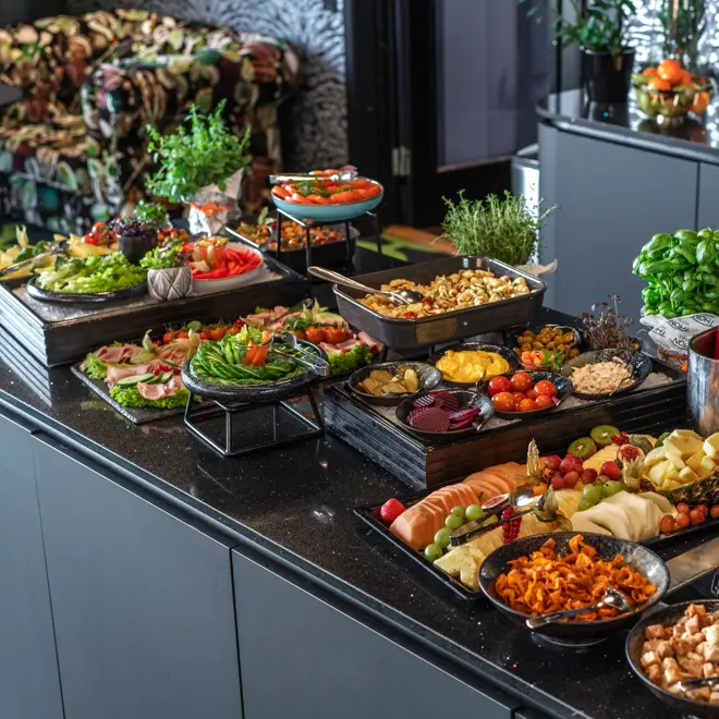 Kveldsmat på buffet med fargerike oppkuttede grønnsaker og frukt, suppe med tilbehør.