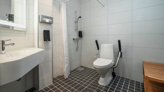 Baderom på handicapvennlig rom på Thon Hotel Maritim, med vask, toalett og dusj med dusjforheng.